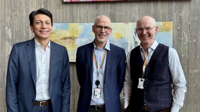 Tre bydelsdirektører står og smiler ved siden av hverandre.