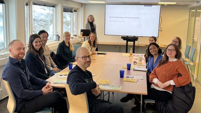 Bildet viser mennesker som sitter rundt et bord.