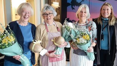 Bilde av de tre frivillige damene med blomsterbuketter og seksjonsleder Heidi.