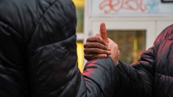 Nærbilde av to hender som holder hverandre i et kameratslig grep.