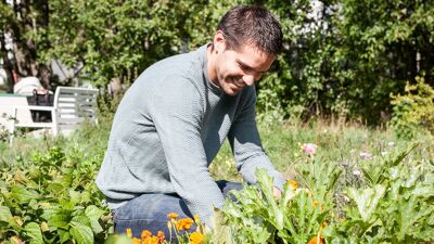 Mann jobber i blomstereng.