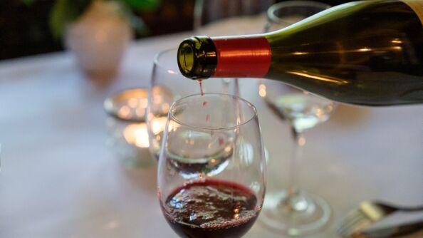 Rødvin helles i et vinglass.