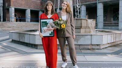Anne Dubrau og byråd for miljø og samferdsel, Sirin Stav, med blomster og diplom foran Oslo rådhus