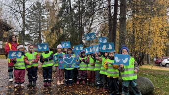 Barn fra Prinsdalsbråten Barnehage har samlet seg, klare til å gå i FNs solidaritetstog for barn. De har på seg regntøy og gule vester.