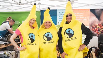 Tre mennesker ikledd banankostymer med Fairtrade-logo