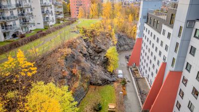 Dronefoto av stein og jord som har rast ut fra skråning mellom blokker.