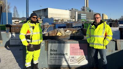 To menn i gule jakker foran container
