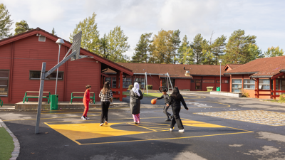 Bilde av elever som spiller basketball i skolegården på Bjørndal skole.
