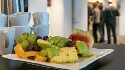 Bilde av fruktfat og mennesker på vei inn en dør