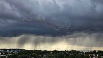 Mørke skyer med regn henger over byen.