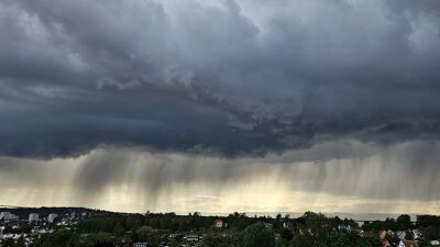 Mørke skyer med regn henger over byen.