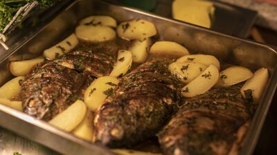 Stekt fisk i en stekeform med poteter.