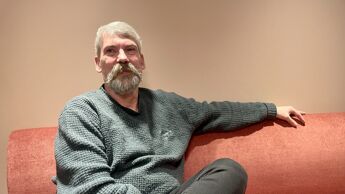 Hovedverneombud Terje Heine Berget sitter i oransje sofa. Han har på seg en grønn genser og grønn bukse.