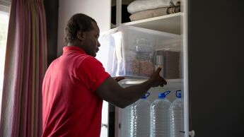 Mann har mat og vann i beredskap i to hyller i klesskapet.