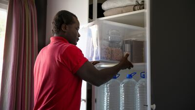 Mann har mat og vann i beredskap i to hyller i klesskapet.