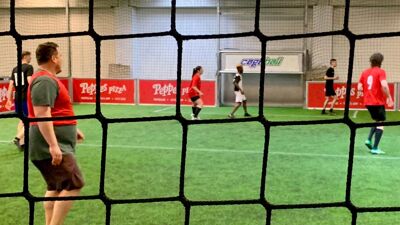 Seks personer spiller fotball på en innebane under Eid Cup 2025