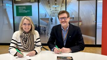 Irene Måsøval, direktør i direktør i Fornebubanen og Berger Johannessen, adm. dir. i Implenia Norge signerer sluttavtalen