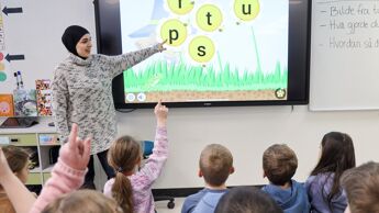 Lører i klasserom underviser en barneskoleklasse.