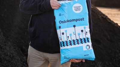 Person holder en sekk med jord.