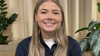 Kvinne med langt blondt hår smiler.