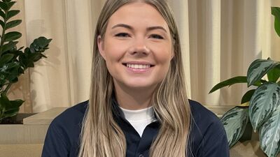 Kvinne med langt blondt hår smiler.