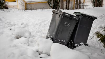 To avfallsbeholdere i dyp snø