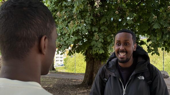 Bilde av Mahad Abdi Jama som står foran "Mohammed" som har ryggen til.