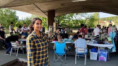 En kvinne står foran et marked under en paviljong.