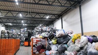 Et stort lager fullt av fulle plastposer med klær.
