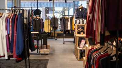 Et butikklokale. Det er klær som henger på stativer.