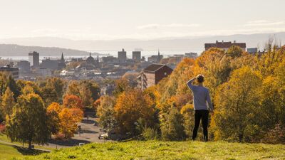 Mann speider utover byen i høstfarger.