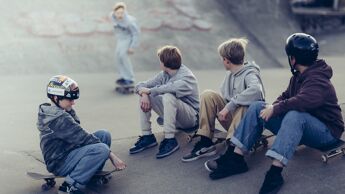 Fire gutter som ser på en gutt skate i en skaterampe.