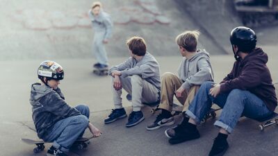 Fire gutter som ser på en gutt skate i en skaterampe.