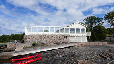 Fasade av Hukodden strandrestaurant, som viser terrassen ved strandsonen.