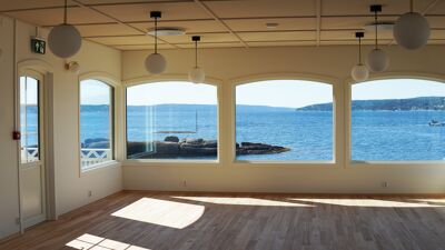 Spisesalen med store vindusflater mot sjøen inne på restauranten. Nytt tregulv er blitt lagt.