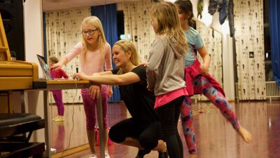 Danselærer Katrine avbildet med tre unge dansere i dansestudio
