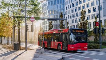 Rød buss fra Ruter kjører på veien