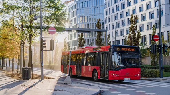 Rød buss fra Ruter kjører på veien