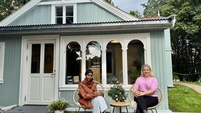 To kvinnelige ansatte foran et nabolagshus.