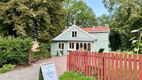 Et stort turkis hus med et rekkverk.