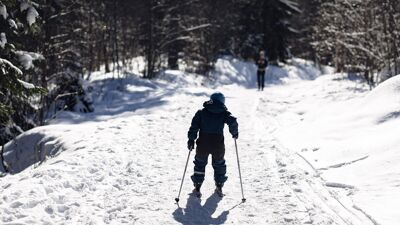 Ungt barn står på ski i oppoverbakke