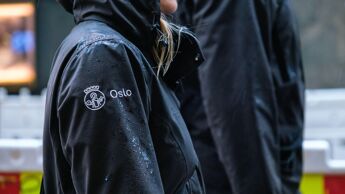 Bilde av  to personer. Hodene er ikke med. På ermet på jakka er det Oslo-logoen.