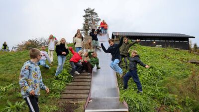 Elevene er opptatt av å vise fram skolens sklie. Her er det også akebakke på vinteren.