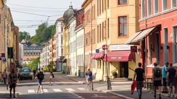 Folk i bevegelse i krysset Thorvald Meyers gate og Korsgata en dag det er vær for shorts.