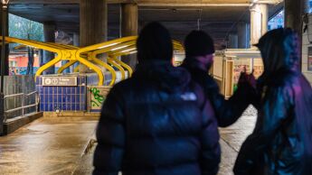 Tre ungdommer med ryggen til hilser på hverandre.