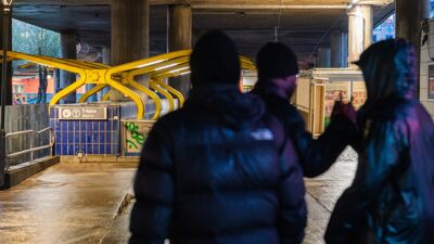 Tre ungdommer med ryggen til hilser på hverandre.