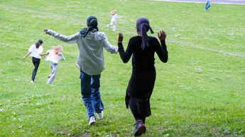 Flere ungdommer løper ned en gressbakke.