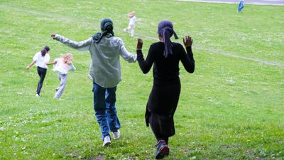 Flere ungdommer løper ned en gressbakke.