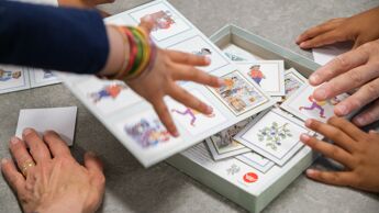 Hender som strekker seg mot et brettspill.