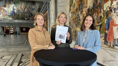 Byråder og NAV direktør holder opp signert avtale bak et rundt bord.